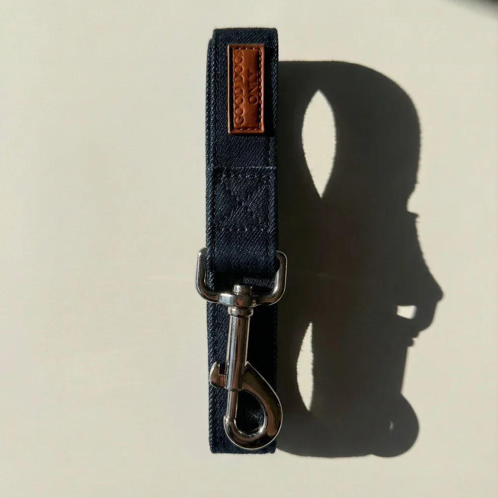 Navy blue dog leash with metal clip on a beige background