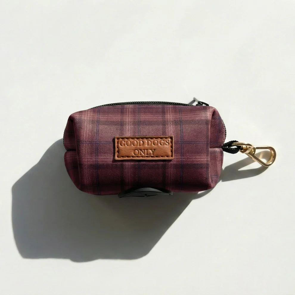 Plaid dog waste pouch with 'Good Dogs Only' label on a white background