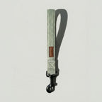 Green dog leash with a brown patch on a light gray background