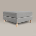 Gray upholstered ottoman with wooden legs on a beige background