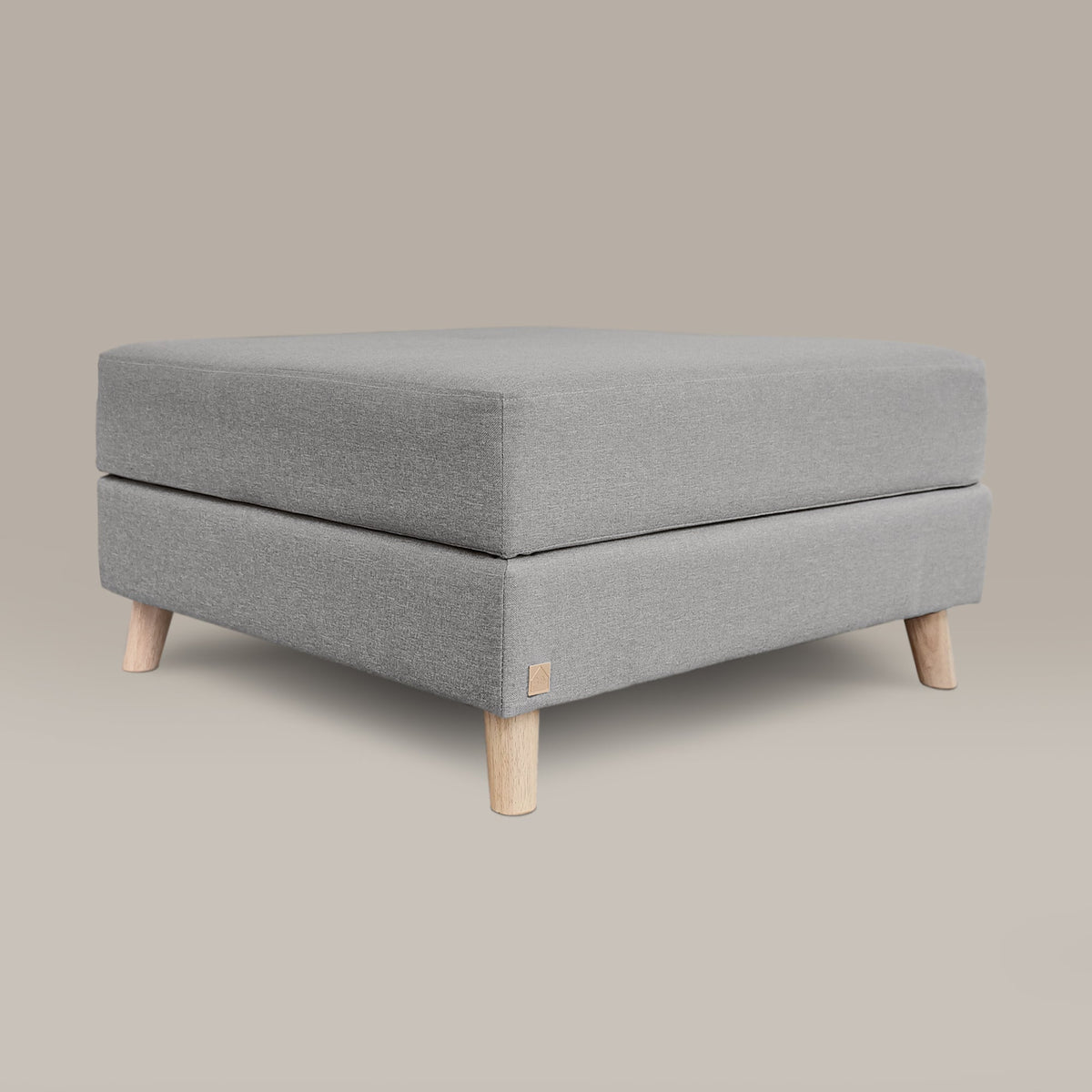 Gray upholstered ottoman with wooden legs on a beige background