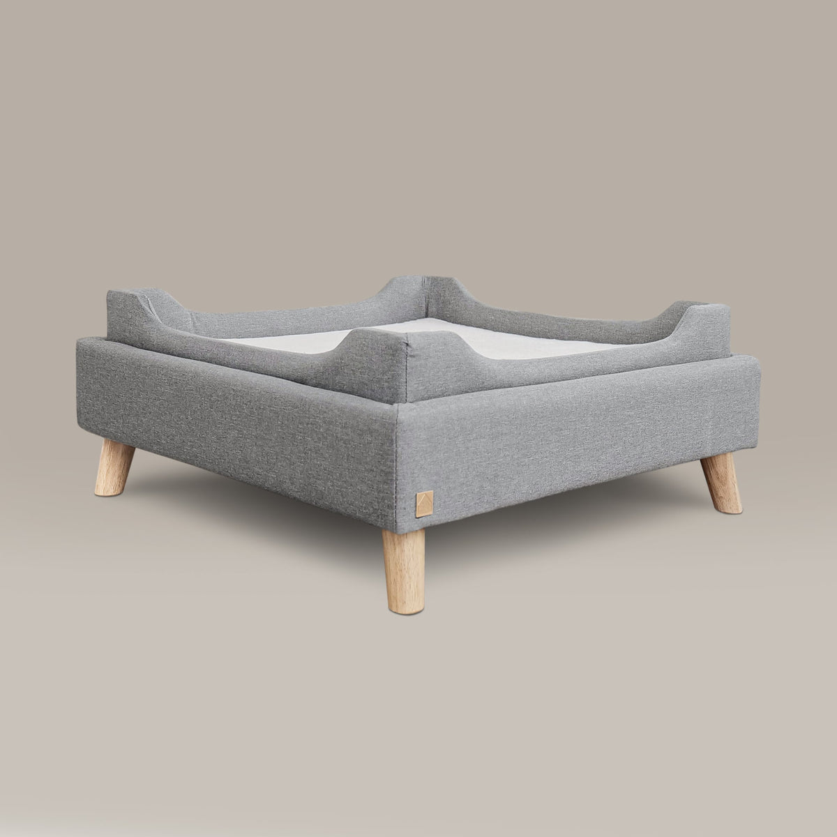Gray pet bed with wooden legs on a beige background