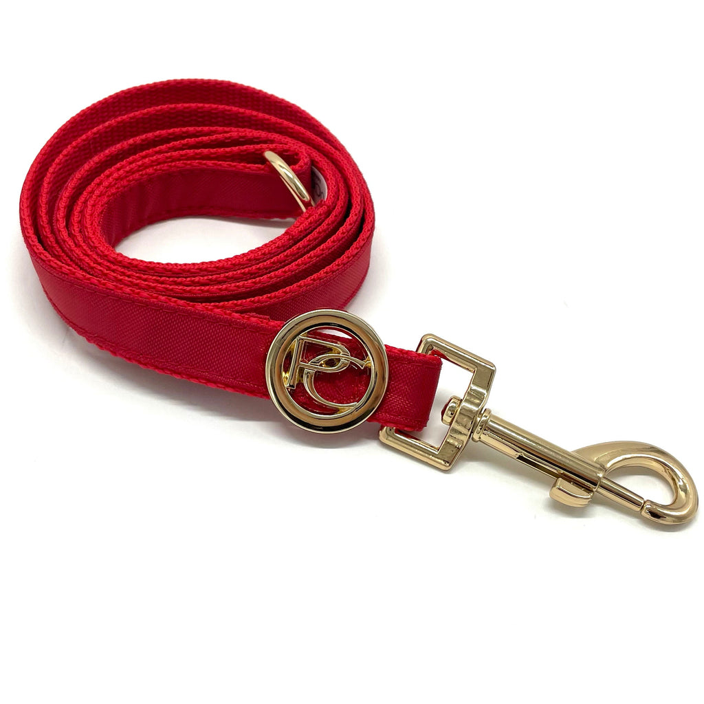 Red dog leash with gold clip and clasp on a white background