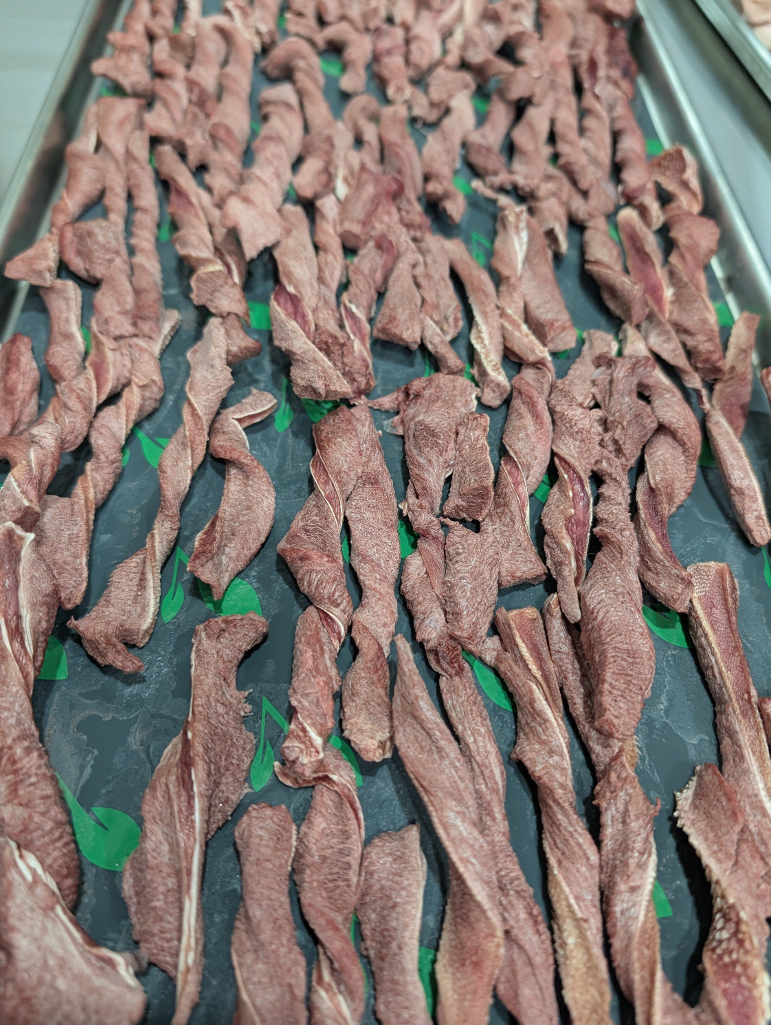 Raw meat strips on a baking tray
