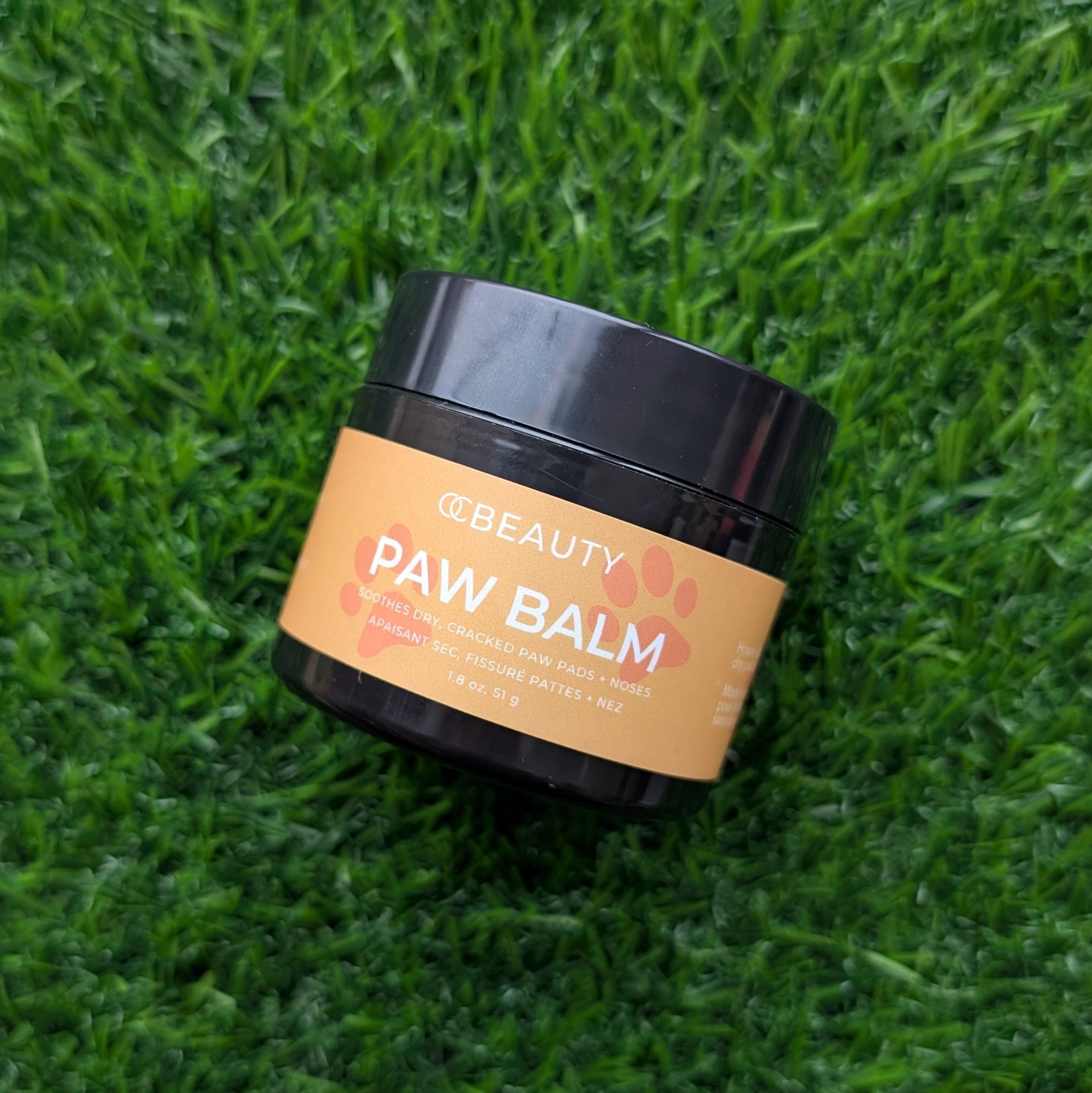 Jar of paw balm on a grass background