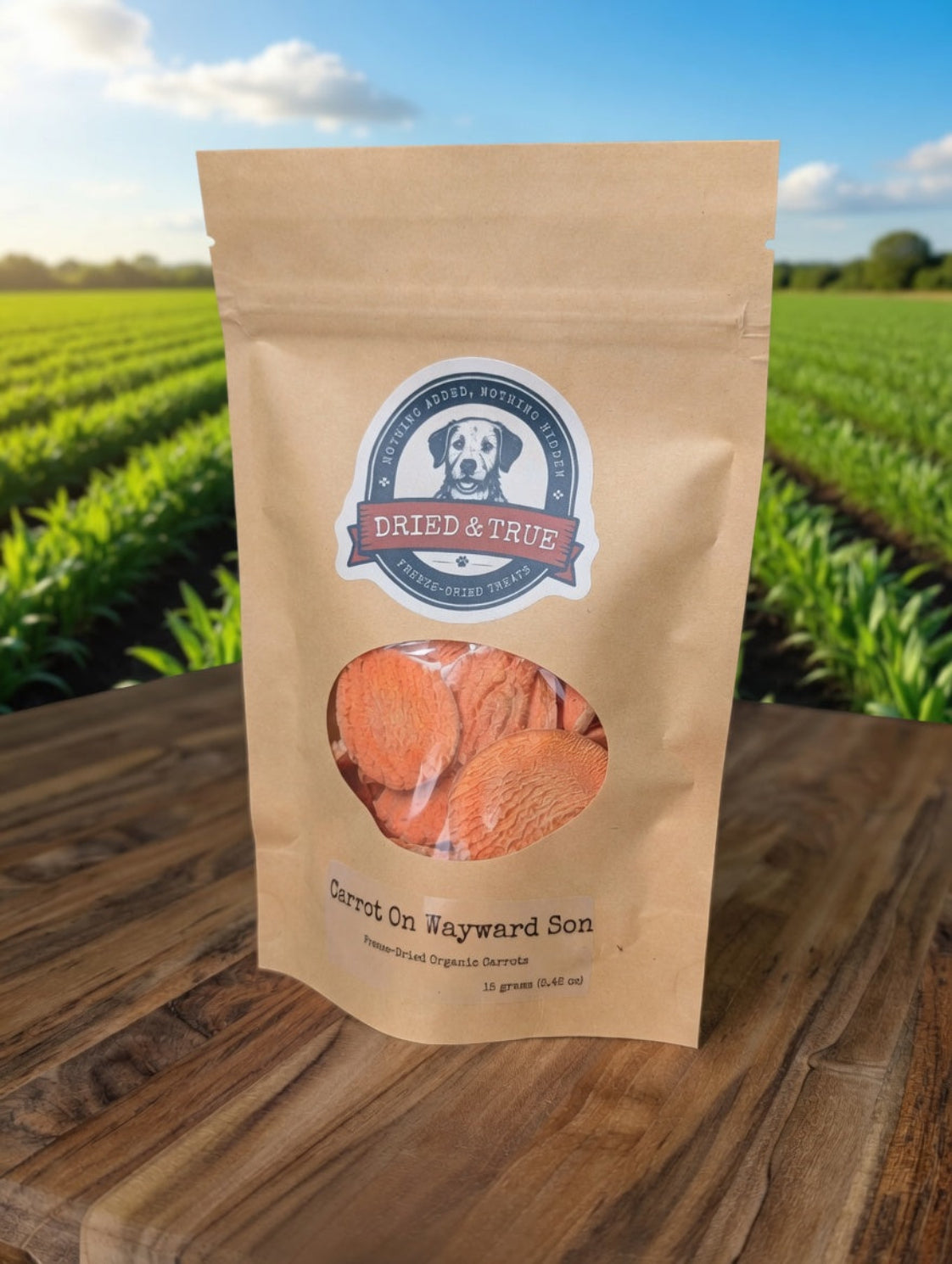 Kraft paper package of 'Dried & True' carrots on a wooden surface with a field in the background