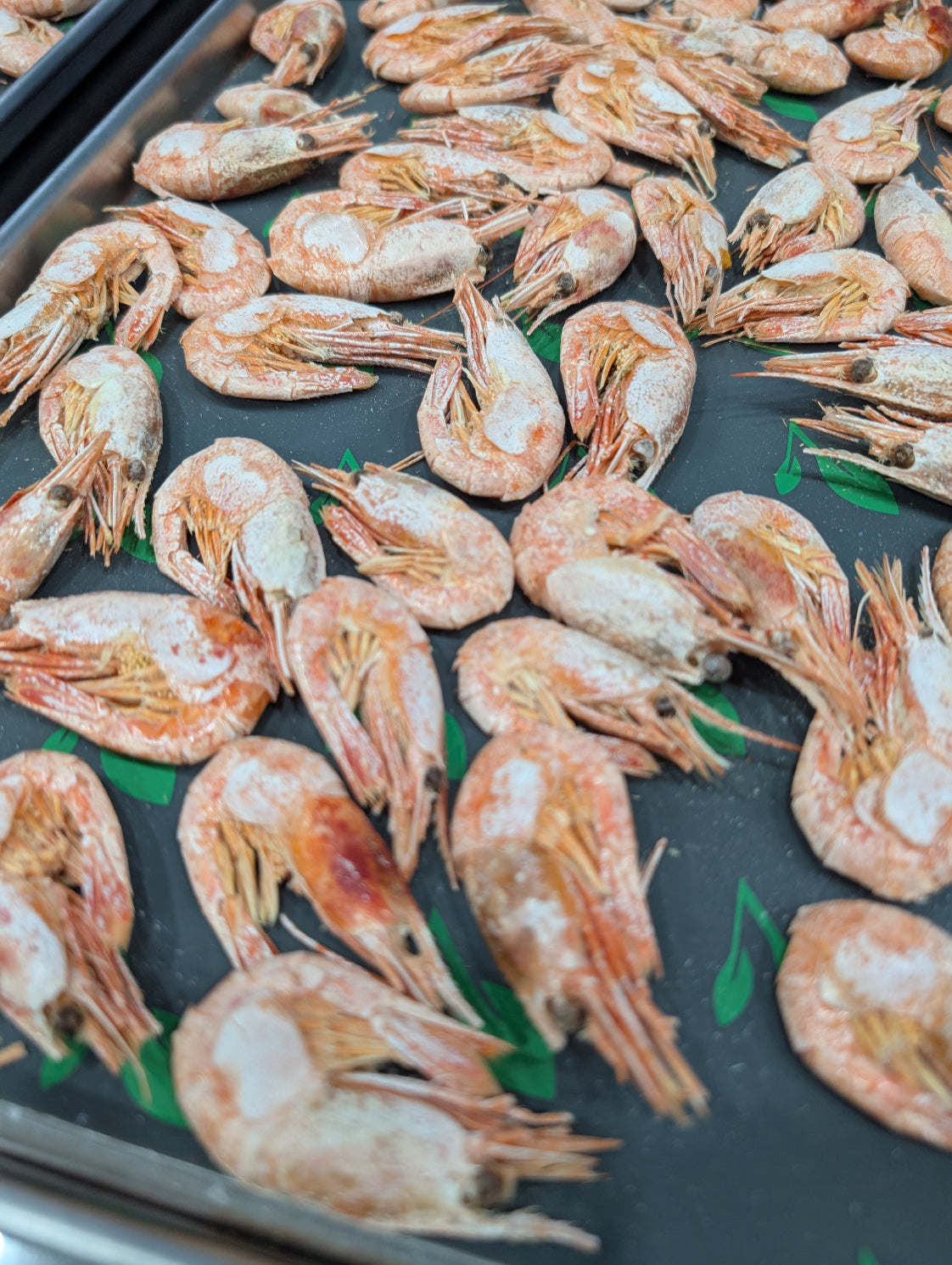 Shrimp on a baking tray with a dark surface