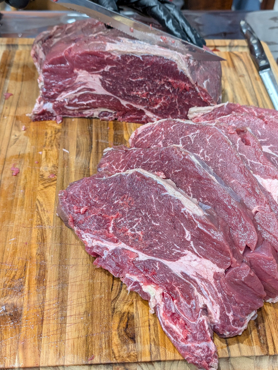 Raw beef steaks on a wooden cutting board