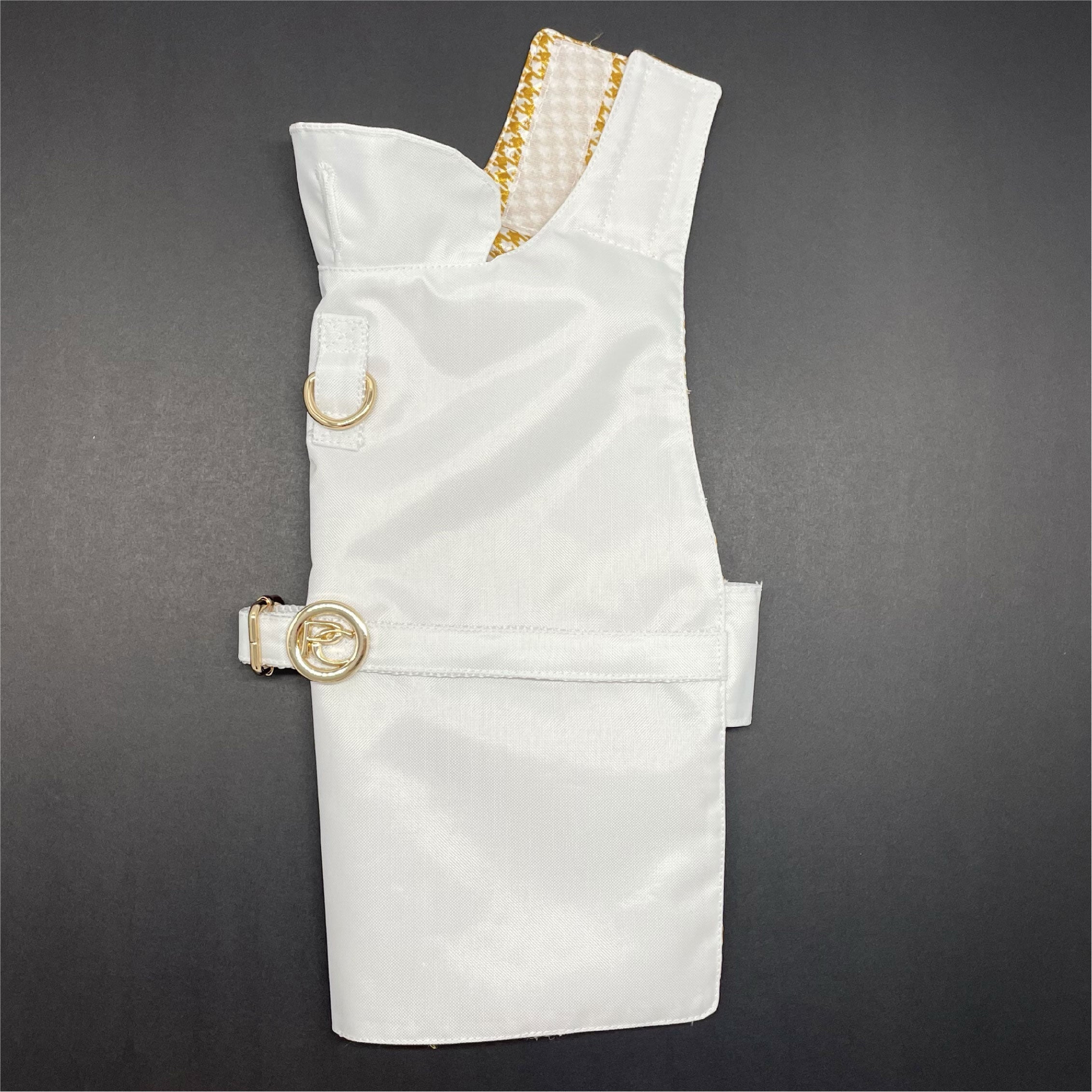 White dog raincoat with gold accents on a gray background