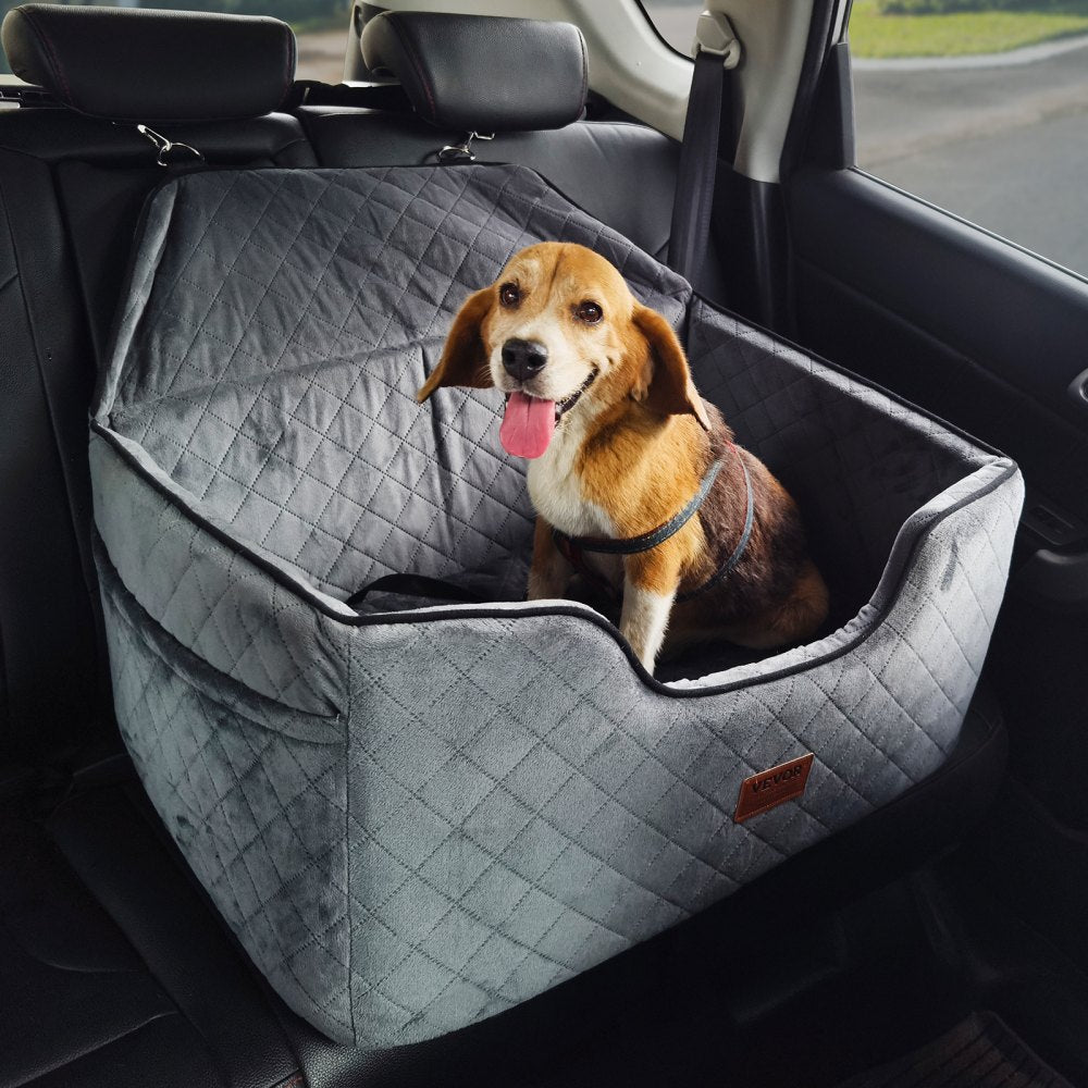 Dog sitting in a gray pet seat in a car