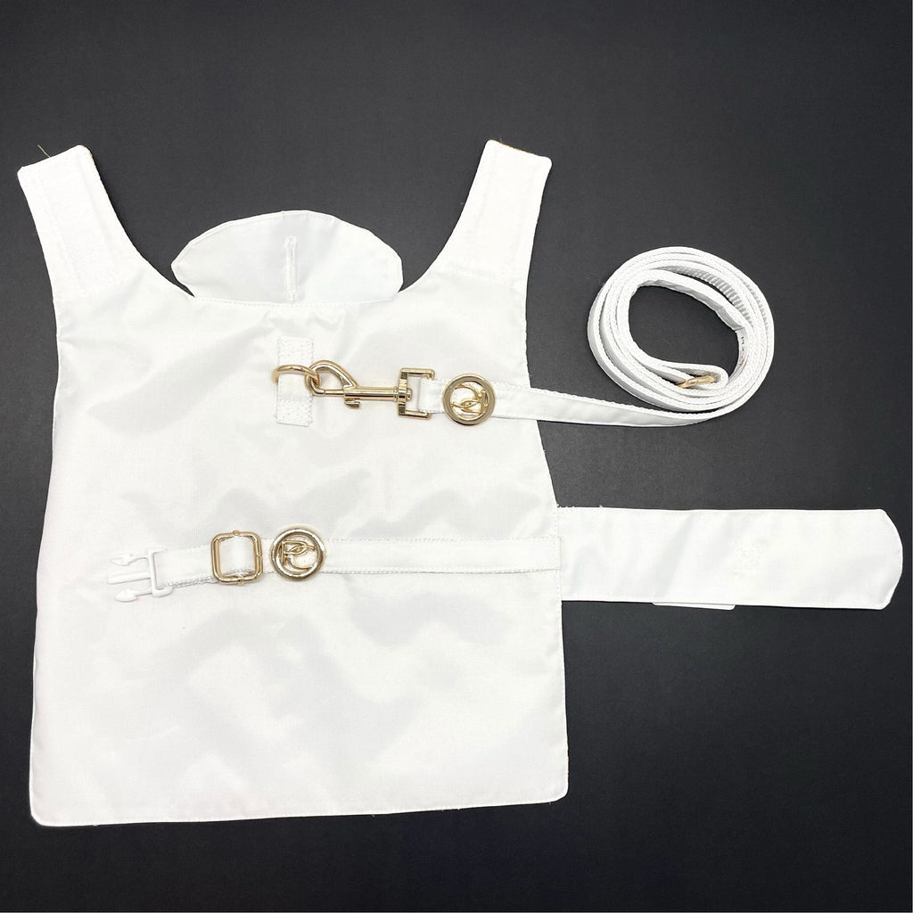White dog raincoat with gold accents on a black background